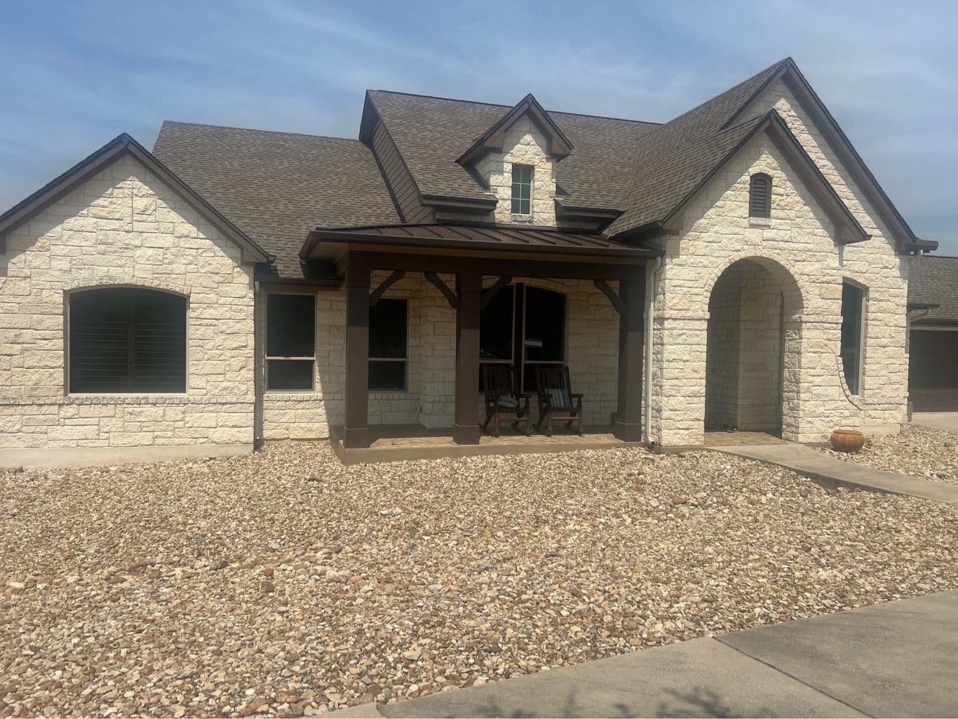 Hill Country stone home with new roof and windows by Glacier Home Exteriors in Dripping Springs TX
